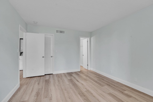 4345 Trevi Ct Unit 108, Lake Worth, FL 33467 - unfurnished bedroom featuring light wood-style flooring, a closet, and a textured ceiling