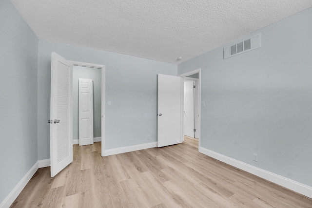 4345 Trevi Ct Unit 108, Lake Worth, FL 33467 - unfurnished bedroom with light wood finished floors and a textured ceiling