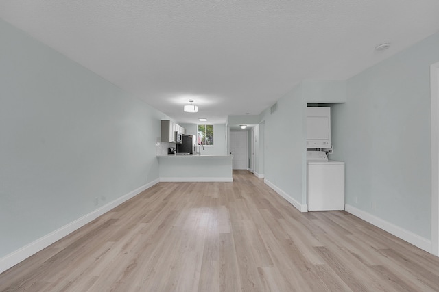 4345 Trevi Ct Unit 108, Lake Worth, FL 33467 - unfurnished living room featuring estacked washer and dryer and light wood finished floors