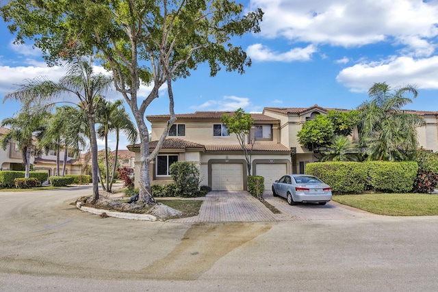 6807 Via Regina Unit 1, Boca Raton, FL 33433 - view of front facade with stucco siding, driveway, an attached garage, and a tiled roof