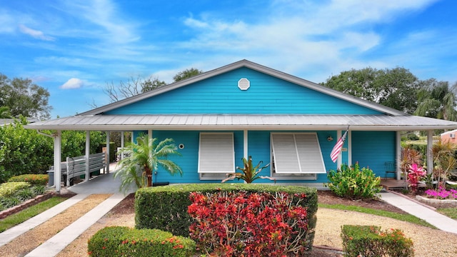2940 SE Treasure Island Rd, Port Saint Lucie, FL 34952 - view of front of home featuring dirt driveway, covered porch, and metal roof