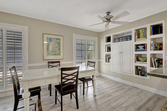 2940 SE Treasure Island Rd, Port Saint Lucie, FL 34952 - dining area featuring light wood-style flooring, baseboards, ceiling fan, and crown molding