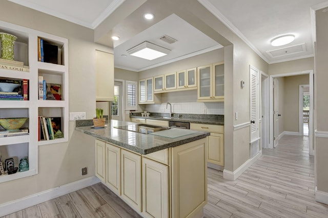 2940 SE Treasure Island Rd, Port Saint Lucie, FL 34952 - kitchen featuring cooktop, visible vents, a peninsula, glass insert cabinets, and cream cabinets
