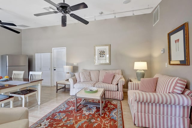 2940 SE Treasure Island Rd, Port Saint Lucie, FL 34952 - living room with a ceiling fan, visible vents, a high ceiling, and rail lighting