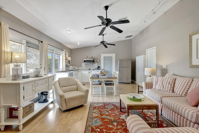 2940 SE Treasure Island Rd, Port Saint Lucie, FL 34952 - living room featuring light wood finished floors, vaulted ceiling, visible vents, and ceiling fan