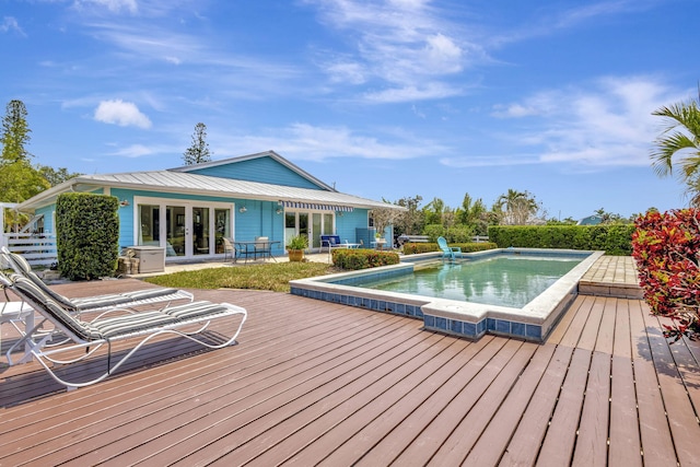 2940 SE Treasure Island Rd, Port Saint Lucie, FL 34952 - outdoor pool featuring a wooden deck and french doors