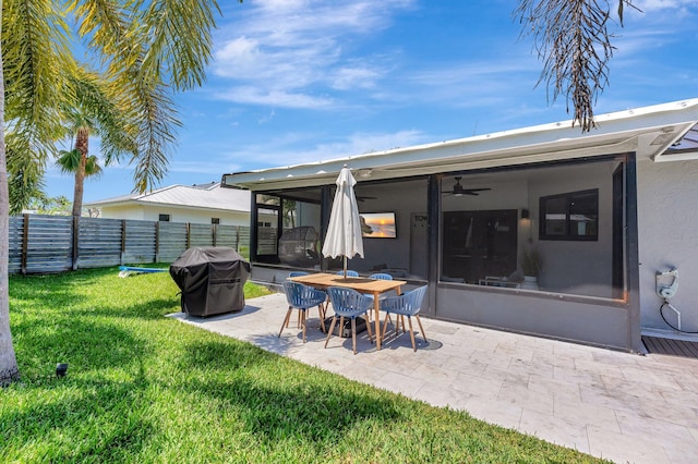 rear view of property with fence, a yard, a patio, stucco siding, and a ceiling fan