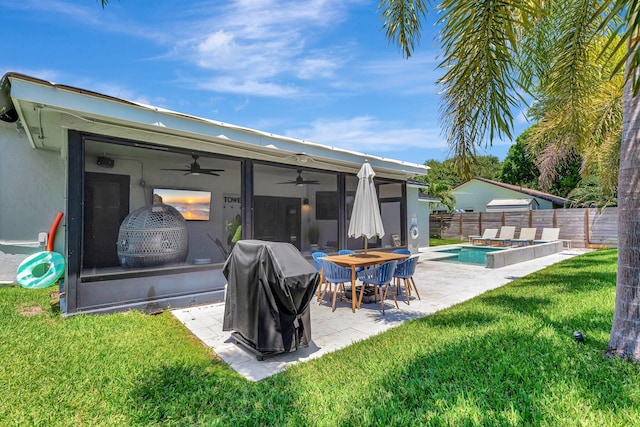 rear view of house with a patio area, a fenced backyard, a fenced in pool, a ceiling fan, and a lawn