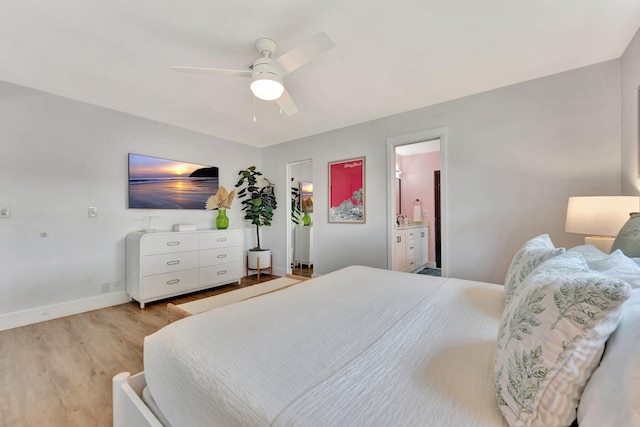 bedroom with baseboards, connected bathroom, light wood-type flooring, and a ceiling fan