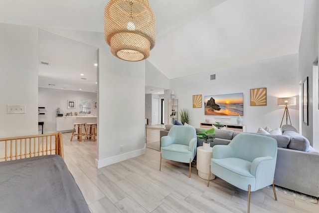 living area with visible vents, baseboards, and high vaulted ceiling