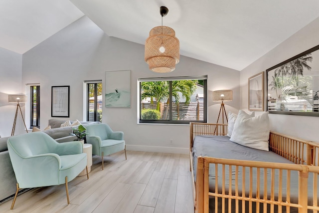 bedroom featuring lofted ceiling, baseboards, and wood finished floors