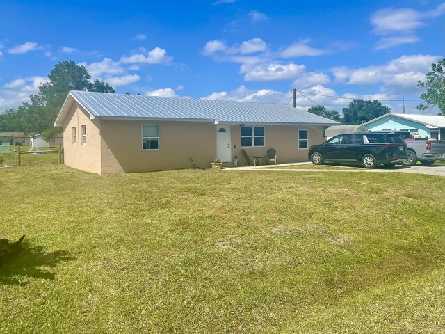 7677 NW 90th Ct, Okeechobee, FL 34972 - view of front of home with stucco siding, a front yard, and metal roof