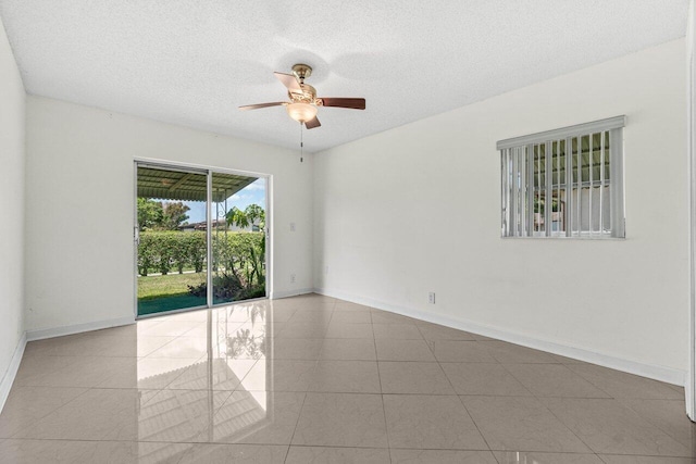 unfurnished room with tile patterned floors, baseboards, a ceiling fan, and a textured ceiling