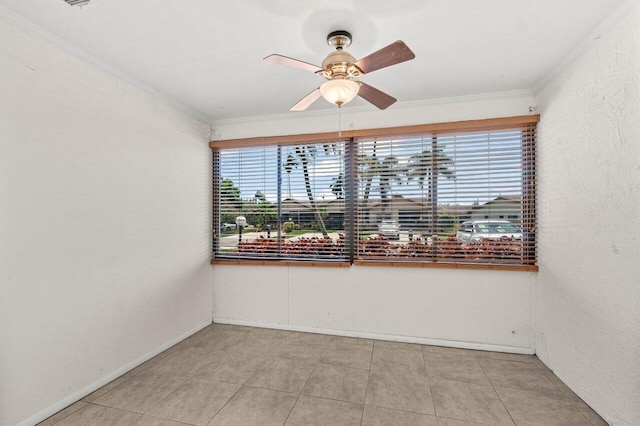 empty room featuring baseboards, ornamental molding, and a ceiling fan