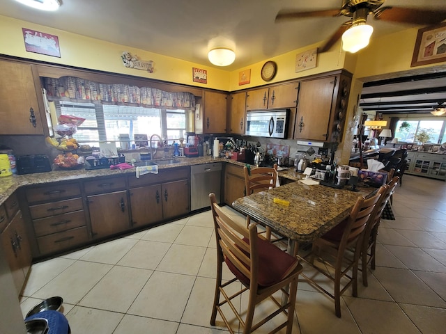 370 SE 14th Ave, Pompano Beach, FL 33060 - kitchen with appliances with stainless steel finishes, a sink, light tile patterned floors, a ceiling fan, and decorative backsplash