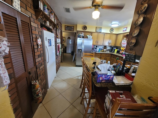 370 SE 14th Ave, Pompano Beach, FL 33060 - kitchen featuring stainless steel refrigerator with ice dispenser, freestanding refrigerator, light tile patterned floors, ceiling fan, and brown cabinets
