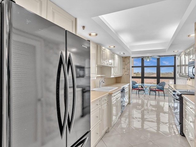 4740 S Ocean Blvd Unit 606, Highland Beach, FL 33487 - kitchen featuring a wall of windows, ceiling fan, light countertops, a raised ceiling, and black appliances