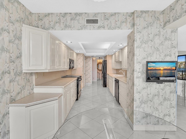 4740 S Ocean Blvd Unit 606, Highland Beach, FL 33487 - kitchen with visible vents, light countertops, a sink, black appliances, and wallpapered walls