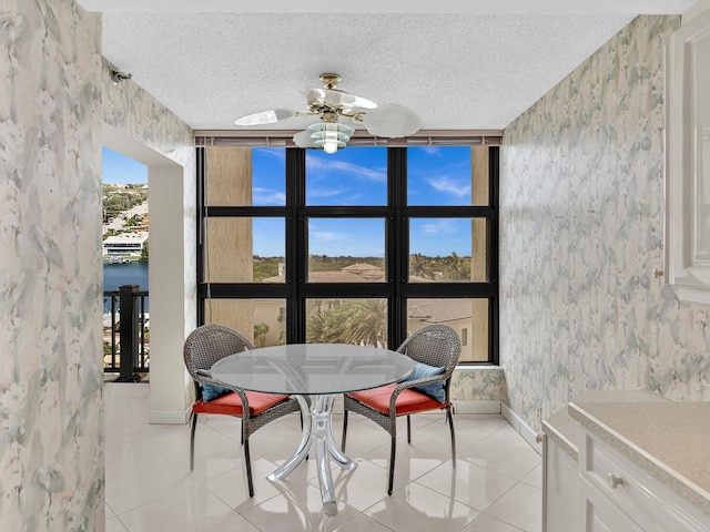 4740 S Ocean Blvd Unit 606, Highland Beach, FL 33487 - dining space with baseboards, a textured ceiling, light tile patterned flooring, and wallpapered walls
