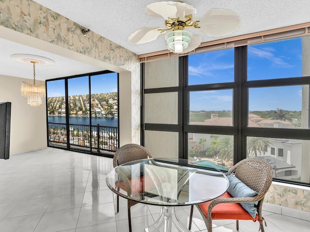 4740 S Ocean Blvd Unit 606, Highland Beach, FL 33487 - tiled dining space with a water view, ceiling fan with notable chandelier, and a textured ceiling