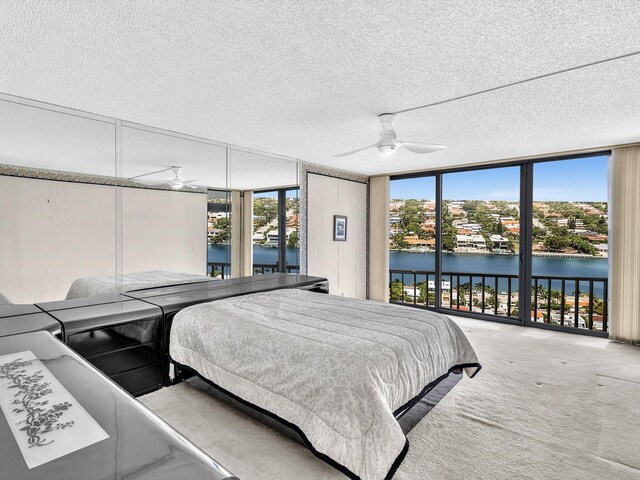 4740 S Ocean Blvd Unit 606, Highland Beach, FL 33487 - bedroom with access to outside, carpet floors, a textured ceiling, a water view, and expansive windows