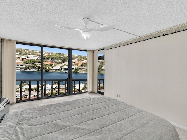 4740 S Ocean Blvd Unit 606, Highland Beach, FL 33487 - bedroom with a wall of windows, a ceiling fan, a textured ceiling, a water view, and access to outside