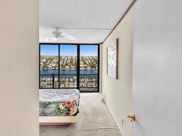 4740 S Ocean Blvd Unit 606, Highland Beach, FL 33487 - carpeted bedroom featuring ceiling fan, a wall of windows, a textured ceiling, access to exterior, and baseboards