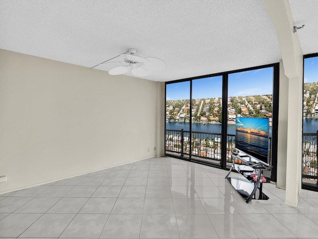 4740 S Ocean Blvd Unit 606, Highland Beach, FL 33487 - spare room featuring plenty of natural light, a textured ceiling, light tile patterned floors, and a wall of windows