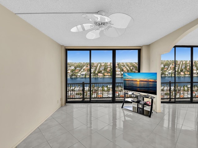 4740 S Ocean Blvd Unit 606, Highland Beach, FL 33487 - living room with arched walkways, a ceiling fan, floor to ceiling windows, and tile patterned floors