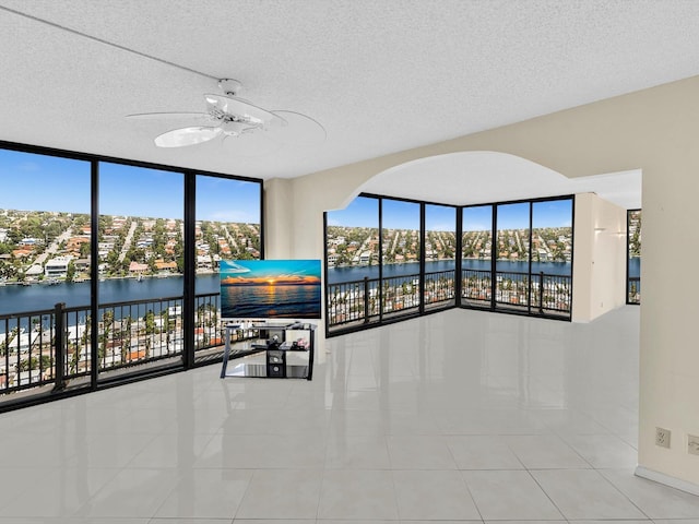 4740 S Ocean Blvd Unit 606, Highland Beach, FL 33487 - tiled spare room featuring a ceiling fan, a textured ceiling, and plenty of natural light