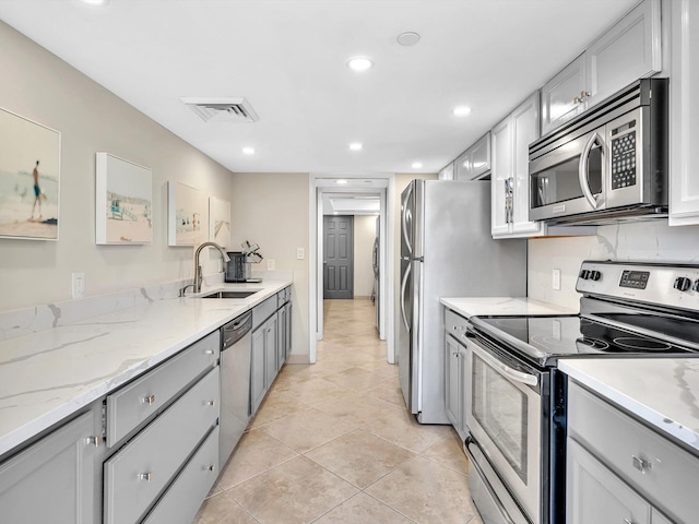4740 S Ocean Blvd Unit 606, Highland Beach, FL 33487 - kitchen with gray cabinetry, light tile patterned flooring, appliances with stainless steel finishes, and a sink