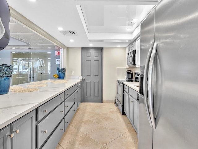 4740 S Ocean Blvd Unit 606, Highland Beach, FL 33487 - kitchen with visible vents, light stone countertops, gray cabinetry, light tile patterned floors, and stainless steel appliances