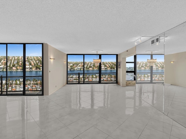 4740 S Ocean Blvd Unit 606, Highland Beach, FL 33487 - empty room with a textured ceiling, a wall of windows, tile patterned floors, and visible vents