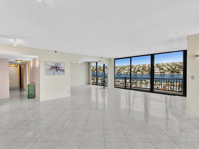 4740 S Ocean Blvd Unit 606, Highland Beach, FL 33487 - tiled spare room featuring a wall of windows, a water view, and a textured ceiling