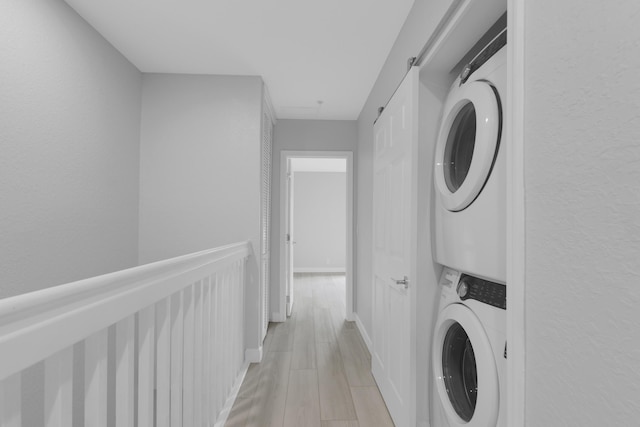 324 Bayfront Dr, Boynton Beach, FL 33435 - laundry area with baseboards, stacked washer and clothes dryer, and light wood-type flooring