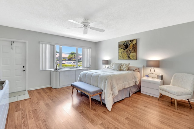 14699 Canalview C Dr Unit C, Delray Beach, FL 33484 - bedroom featuring light wood-style flooring, a textured ceiling, ceiling fan, and baseboards