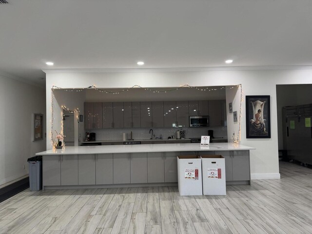 14699 Canalview C Dr Unit C, Delray Beach, FL 33484 - kitchen featuring stainless steel microwave, crown molding, gray cabinets, a sink, and light wood-type flooring