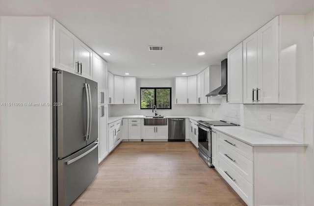 15763 Alexander Run, Jupiter, FL 33478 - kitchen with stainless steel appliances, wall chimney exhaust hood, a sink, light countertops, and light wood finished floors