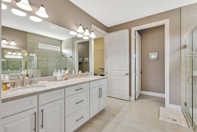 420 SE Bancroft Ct, Port Saint Lucie, FL 34984 - full bathroom featuring a stall shower, double vanity, a spacious closet, and baseboards