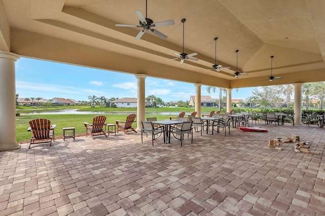 view of patio with outdoor dining area, a water view, a residential view, and a ceiling fan