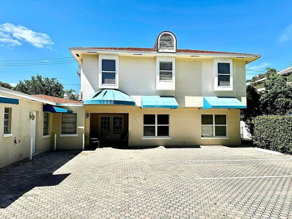 1200 Surf Rd, Singer Island, FL 33404 - view of front of property with french doors, a patio, and stucco siding