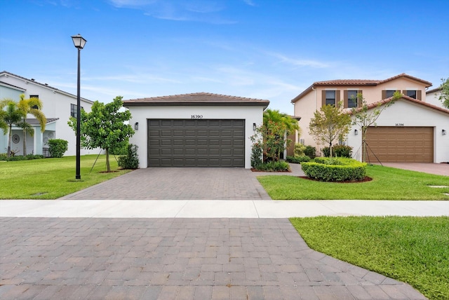 16390 Sea Turtle Pl, The Acreage, FL 33470 - view of front of property featuring a tiled roof, stucco siding, an attached garage, decorative driveway, and a front yard