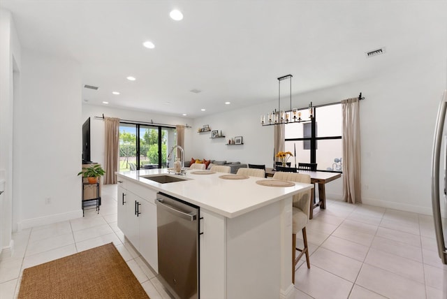 16390 Sea Turtle Pl, The Acreage, FL 33470 - kitchen with white cabinets, an island with sink, dishwasher, a sink, and a kitchen bar