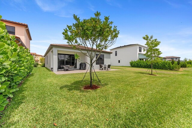 16390 Sea Turtle Pl, The Acreage, FL 33470 - rear view of property with a yard, a patio area, a tile roof, and stucco siding