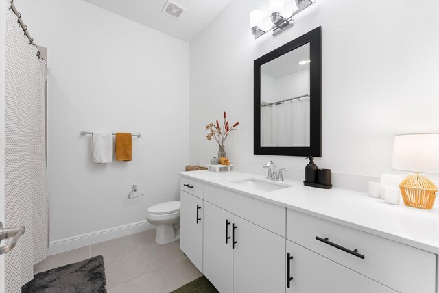 16390 Sea Turtle Pl, The Acreage, FL 33470 - bathroom with vanity, baseboards, toilet, tile patterned flooring, and visible vents