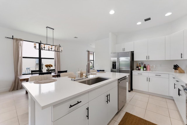 16390 Sea Turtle Pl, The Acreage, FL 33470 - kitchen featuring stainless steel appliances, a sink, a center island with sink, a notable chandelier, and light tile patterned floors