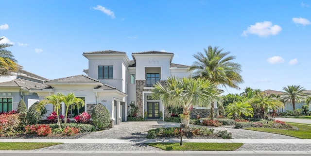 2560 NW 70th Blvd, Boca Raton, FL 33496 - mediterranean / spanish home featuring french doors, stucco siding, decorative driveway, and stone siding