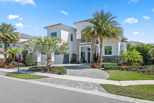 2560 NW 70th Blvd, Boca Raton, FL 33496 - view of front facade featuring stucco siding, decorative driveway, a tile roof, stone siding, and an attached garage
