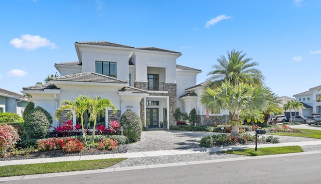 2560 NW 70th Blvd, Boca Raton, FL 33496 - mediterranean / spanish house featuring driveway, a balcony, stone siding, stucco siding, and french doors