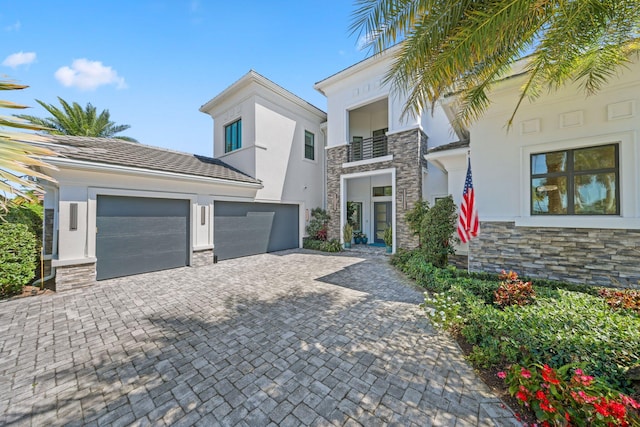 2560 NW 70th Blvd, Boca Raton, FL 33496 - view of front of home featuring stucco siding, decorative driveway, and stone siding